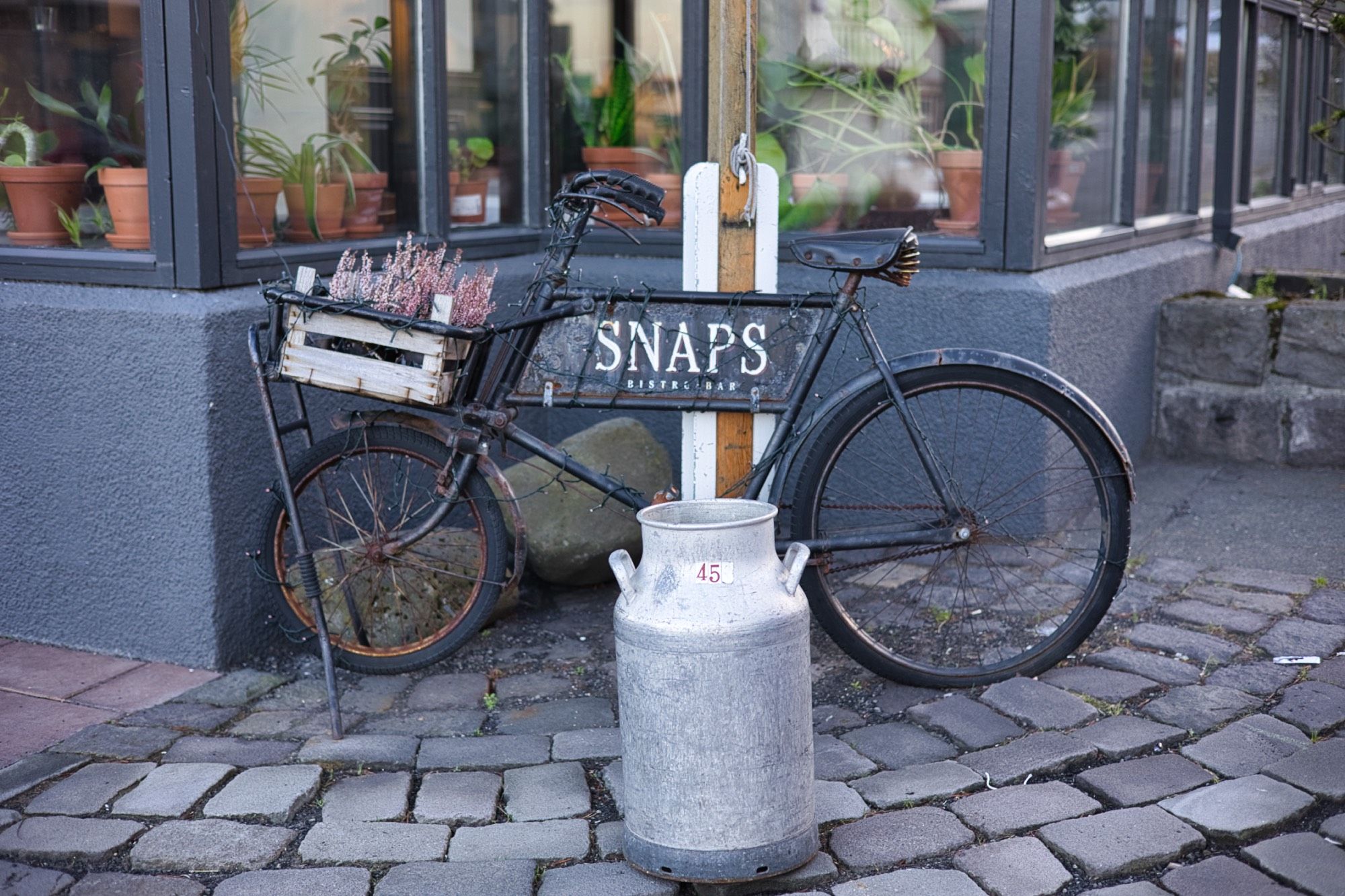 A vintage rusted bicycle serving as a sign for Snaps Bistro restaurant